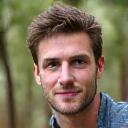 Portrait of Liam O'Connell, Conservation Volunteer Coordinator, next to a newly planted tree.